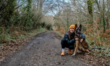 vrouw met muts in een bos met een herder